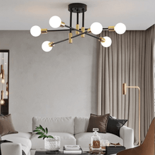 Load image into Gallery viewer, Black & Gold LED Chandelier in living room above the sofa