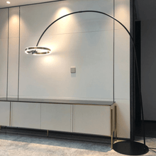 Load image into Gallery viewer, Black Creative Designer Ring Floor Lamp next to cabinet
