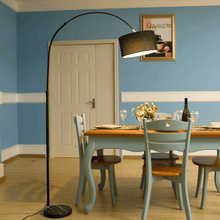 Load image into Gallery viewer, Black Modern Essential Floor Lamp leaning over dining table
