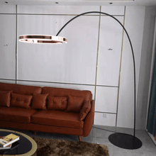 Load image into Gallery viewer, Rose Gold Creative Designer Ring Floor Lamp next to red living room sofa
