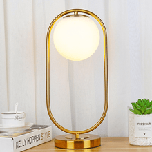 Load image into Gallery viewer, A gold Modern Golden Globe Table Lamp on a desk
