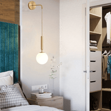 Load image into Gallery viewer, Gold Nordic Globe Wall Light above bedside table in bedroom
