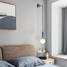 Load image into Gallery viewer, Black Nordic Globe Wall Light above bedside table in bedroom

