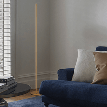 Load image into Gallery viewer, Gold Thin LED Floor Lamp in corner of living room next to sofa
