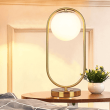 Load image into Gallery viewer, A gold Modern Golden Globe Table Lamp on a coffee table
