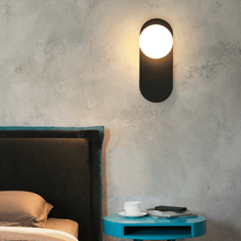 Load image into Gallery viewer, Black Flat Base Globe Light above blue bedside table next to bed
