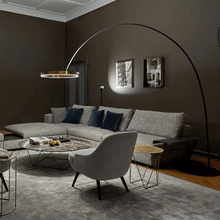 Load image into Gallery viewer, Gold Creative Designer Ring Floor Lamp next to grey corner sofa in living room
