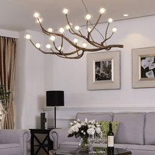 Load image into Gallery viewer, Rustic Tree Branch Pendant Light above coffee table and sofa in living room
