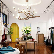 Load image into Gallery viewer, Rustic Tree Branch Pendant Light above table in clothes shop
