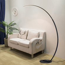 Load image into Gallery viewer, Black Nordic Arc Floor Lamp next to small sofa and plant in living room
