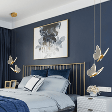 Load image into Gallery viewer, Four gold LED Butterfly Pendant Lights above bedside tables either side of bed in bedroom
