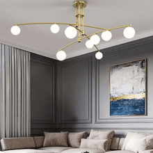 Load image into Gallery viewer, Gold Modern Long Arm Chandelier above sofa in living room with painting on the wall
