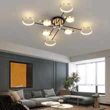 Load image into Gallery viewer, Gold Modern Neutral Chandelier above coffee tables and corner sofa in living room
